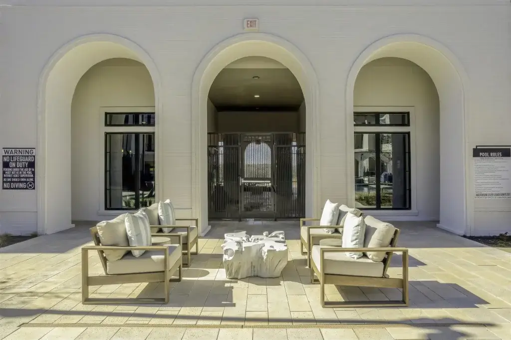 Outdoor lounge seating beneath arched patio openings at the Parker at Walsh pool courtyard
