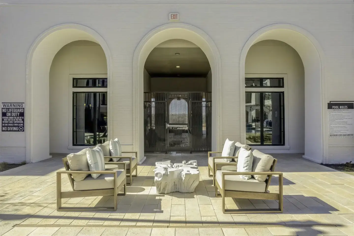 Outdoor lounge seating beneath arched patio openings at the Parker at Walsh pool courtyard