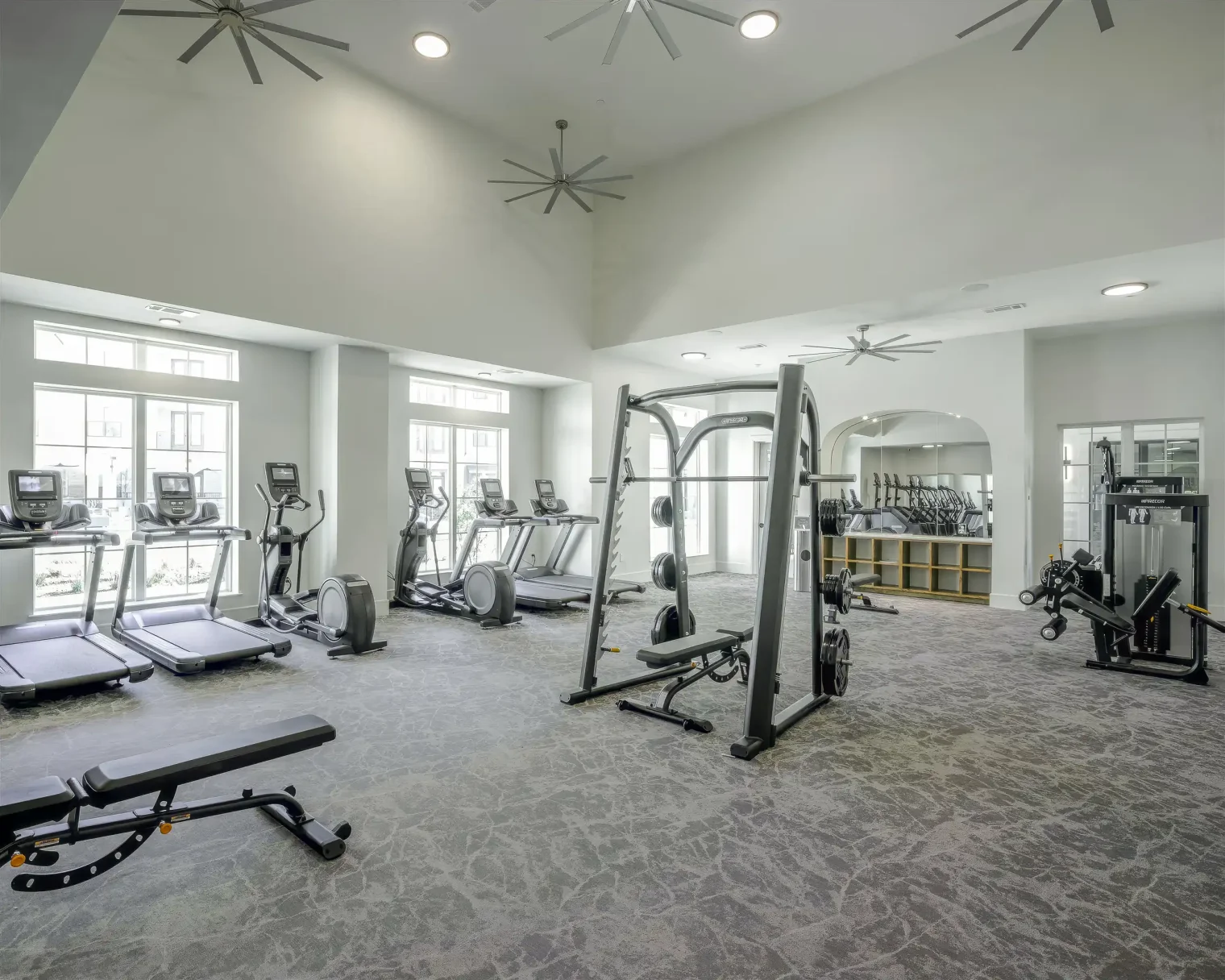 Fitness center with cardio and strength training equipment at Parker at Walsh apartments