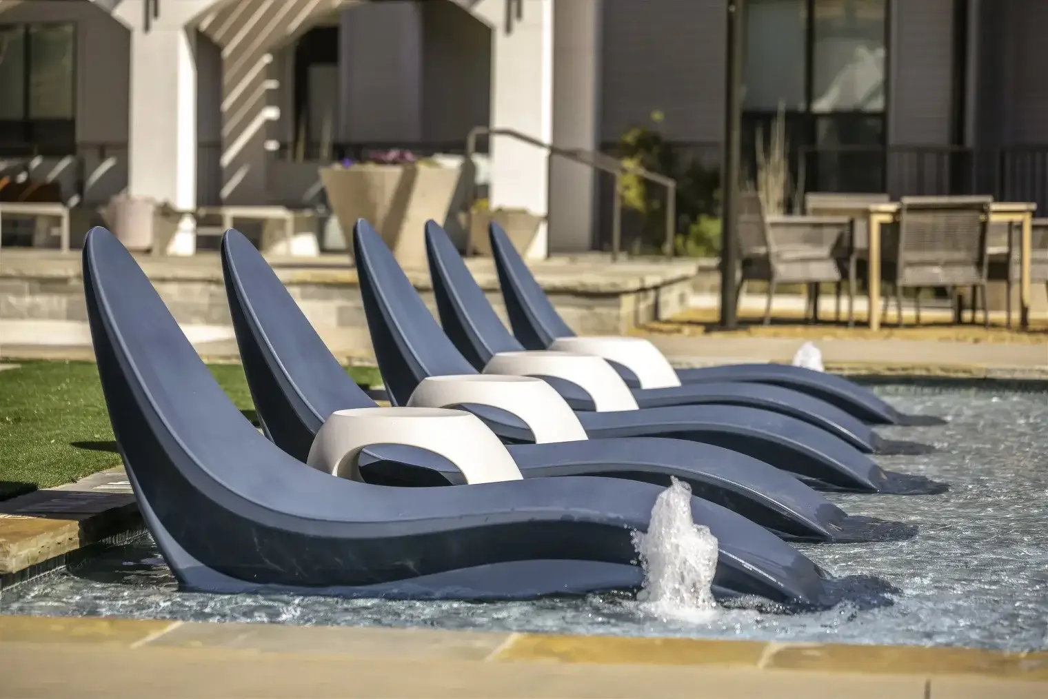 In-water lounge chairs and water features at the Parker at Walsh resort-style pool